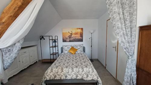 1 dormitorio con 1 cama con almohada amarilla en L'appel de la foret, en Lyons-la-Forêt