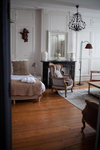 a bedroom with a bed and a chair and a mirror at Bienvenue Chez Nous in Bergues