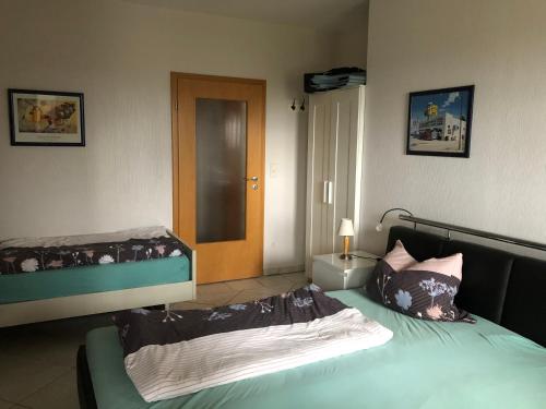 1 dormitorio con 2 camas y puerta que da a un pasillo en Feldjahns-Ferienwohnung en Ahaus