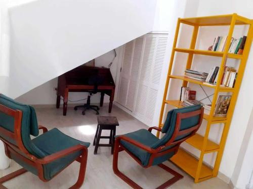 a living room with two chairs and a piano at Magnifique villa en Centre Ville in Monastir