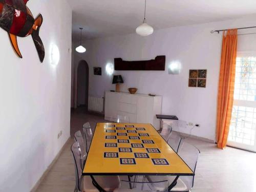 a dining room with a yellow table and chairs at Magnifique villa en Centre Ville in Monastir
