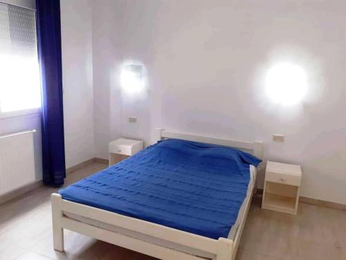 ein Schlafzimmer mit einem Bett mit einer blauen Decke in der Unterkunft Magnifique villa en Centre Ville in Monastir