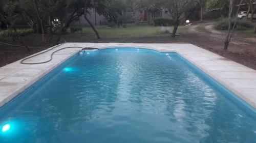 una piscina de agua azul en un patio en Paraiso Serrano en La Población