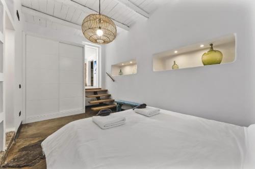 a white bedroom with a bed and a staircase at Villa Atlantico - Planta Baja in Arrecife