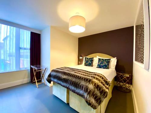 a bedroom with a bed and a large window at Stunning Apartment - 1 Minute walk to Poole Quay - Great Location - Free Parking - Fast WiFi - Smart TV - Newly decorated - sleeps up to 2! Close to Poole & Bournemouth & Sandbanks in Poole