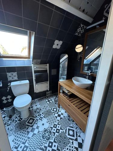 a black and white bathroom with a toilet and a sink at La suite Brésilienne in Forges-les-Eaux