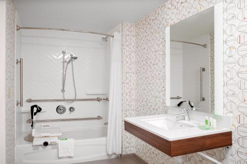 a white bathroom with a sink and a mirror at Holiday Inn & Suites Boston Peabody by IHG in Peabody