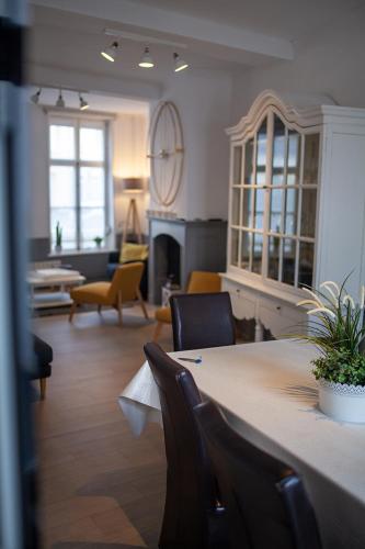 a living room with a table and chairs and a fireplace at Bienvenue Chez Nous in Bergues