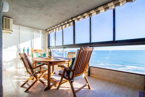 a dining room with a table and chairs and the ocean at ESPACIO 16 - Primera LINEA PLAYA in Cullera