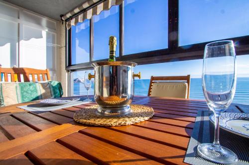 a bottle of wine in a container on a wooden table at ESPACIO 16 - Primera LINEA PLAYA in Cullera