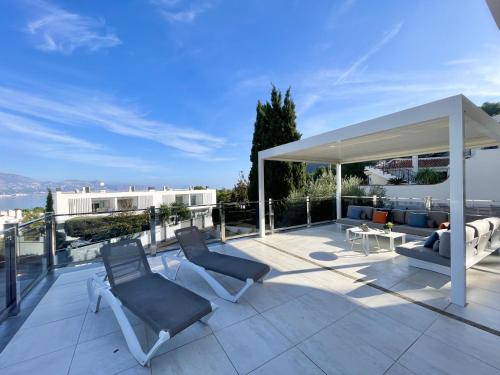 a patio with two chairs and a gazebo at DREAM VILLA IN ALBIR BLUELINE in L'Alfas del Pi