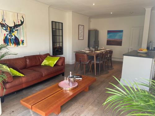 a living room with a couch and a table at Beautiful 4B.2Ba House + office in Raynes Park