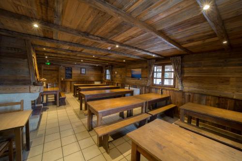a dining room with wooden tables and benches at Le Refuge Du Lachat in Crest-Voland