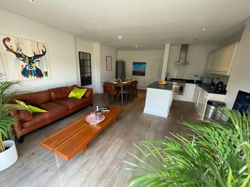 a living room with a couch and a table at Beautiful 4B.2Ba House + office in Raynes Park