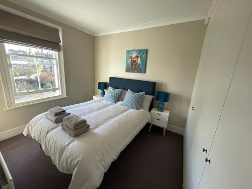 a bedroom with a large bed with towels on it at Beautiful 4B.2Ba House + office in Raynes Park