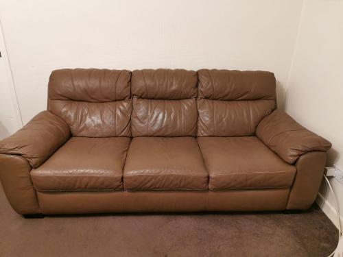 a brown leather couch sitting in a room at Private Room in Coventry in Parkside
