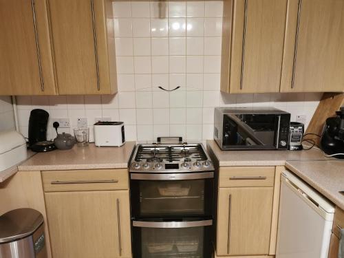 a kitchen with a stove and a microwave at Private Room in Coventry in Parkside