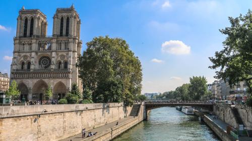 een brug over een rivier voor een kathedraal bij PARIS AUTHENTIC HOUSE Small, bright and calm studio in Parijs