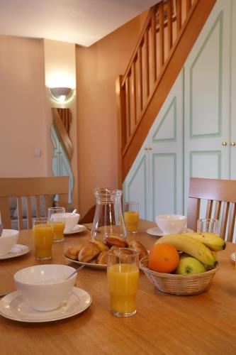 a table with a bowl of fruit and glasses of orange juice at Vacancéole - Les Bastides de Fayence in Tourrettes