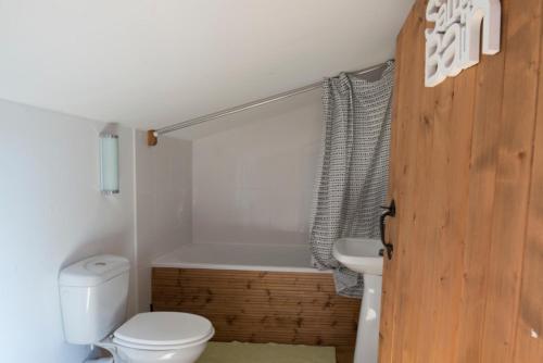 La salle de bains est pourvue de toilettes, d'une baignoire et d'un lavabo. dans l'établissement Domaine Hourcabis - 2 gîtes 4 et 6 personnes, 