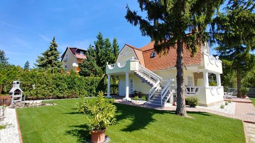 a house with a staircase in a yard at Balaton Apartman Füred in Balatonfüred
