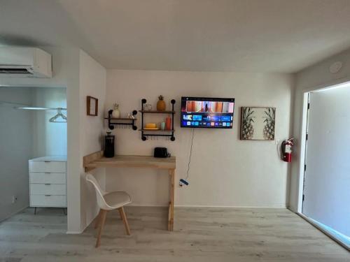 a room with a chair and a tv on a wall at Retro motel walk to beach, Wi-Fi in Daytona Beach