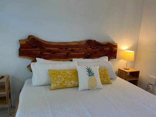 1 cama con almohadas blancas y cabecero de madera en Retro motel walk to beach, Wi-Fi en Daytona Beach