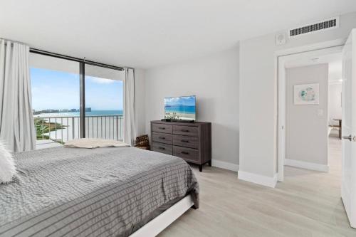 a white bedroom with a bed and a large window at Sst3 #1209 in Marco Island