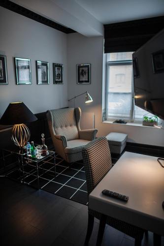 a living room with a couch and chairs and a table at Bienvenue Chez Nous in Bergues