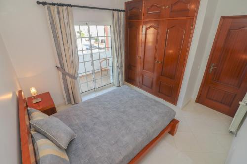 a bedroom with a bed and a large window at Cantinho do Mocho in Pêra