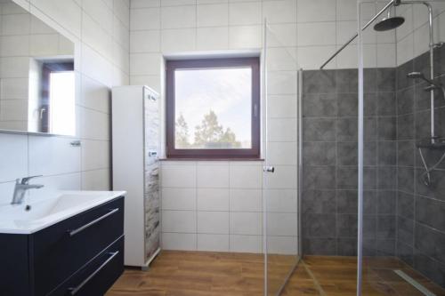 a bathroom with a glass shower and a sink at Willa u Hanysa in Niechorze