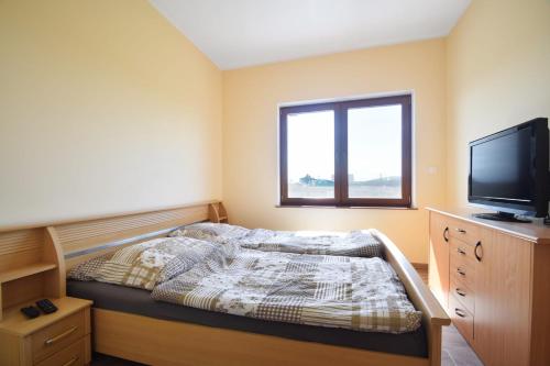 a small bedroom with a bed and a television at Willa u Hanysa in Niechorze