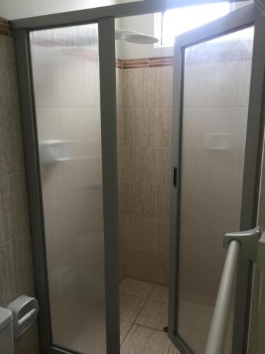 a shower stall with a glass door in a bathroom at Selva Suites in Iquitos