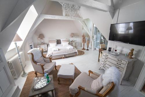 a bedroom with a bed and a tv and chairs at Bienvenue Chez Nous in Bergues