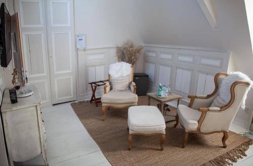a living room with three chairs and a table at Bienvenue Chez Nous in Bergues