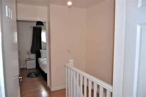 a hallway with a stairway leading to a bedroom at London 4 Bedroom House in London