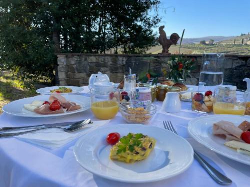 une table blanche avec des assiettes de nourriture dans l'établissement Corte Di Valle, à Greve in Chianti