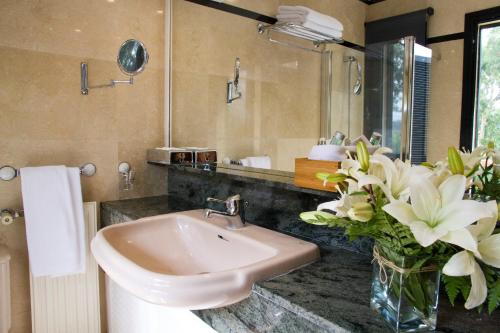 uma casa de banho com um lavatório e um vaso de flores em Hotel Escuela Santa Brígida em Santa Brígida