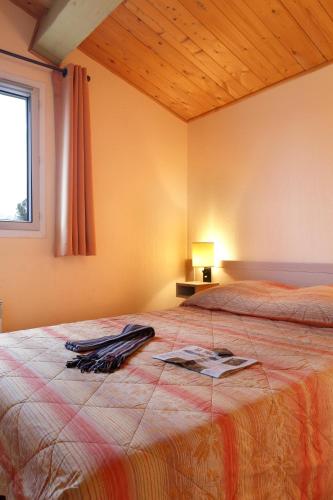 a bedroom with a bed with a robe on it at Vacancéole - Les Bastides de Fayence in Tourrettes