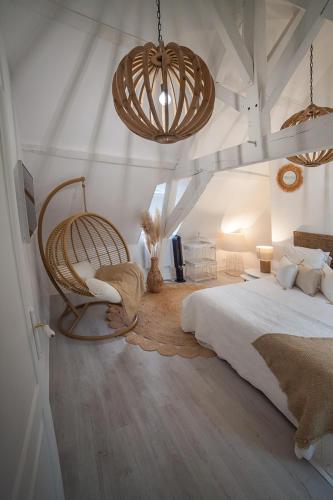 a bedroom with a bed and a hanging chair at Bienvenue Chez Nous in Bergues