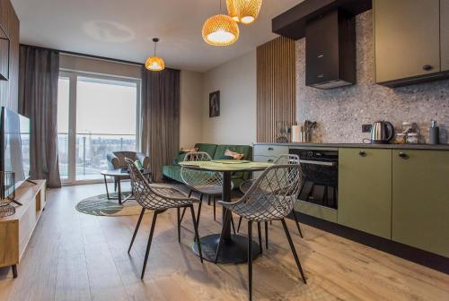 a kitchen and living room with a table and chairs at Cudowny apartament blisko dworca in Białystok