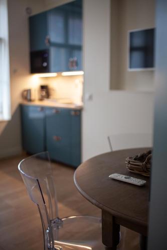 a table and chairs in a kitchen with blue cabinets at Bienvenue Chez Nous in Bergues