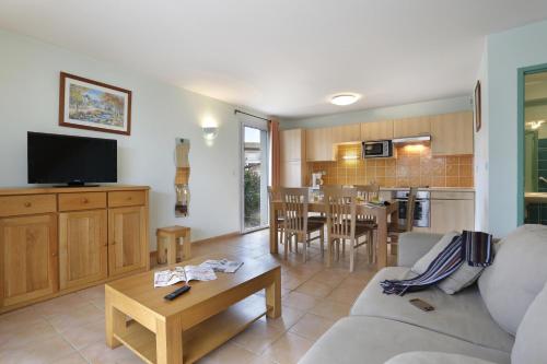 a living room with a couch and a table at Vacancéole - Les Bastides de Fayence in Tourrettes