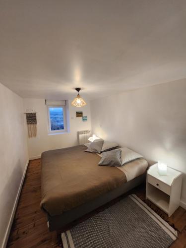 een slaapkamer met een bed, een raam en een lamp bij Figuets 3 in Châteauneuf-de-Galaure