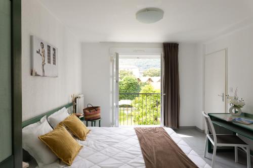 科爾泰的住宿－Appart Hotel Corte HR，一间卧室配有一张床、一张书桌和一个窗户。