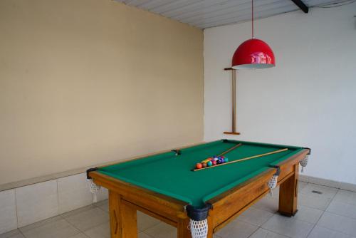 a room with a pool table and a red lamp at Hotel Village Icaraí in Niterói