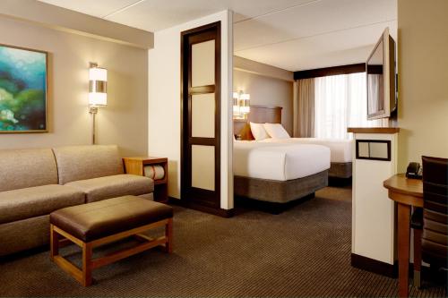 ein Hotelzimmer mit einem Bett und einem Sofa in der Unterkunft Hyatt Place Coconut Point in Estero