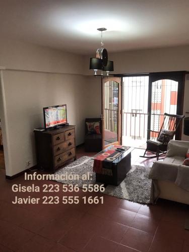 sala de estar con sofá y TV en Departamento Avenida Constitución en Mar del Plata