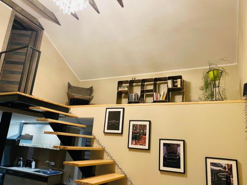 a spiral staircase in a room with pictures on the wall at PILADZI in Sigulda