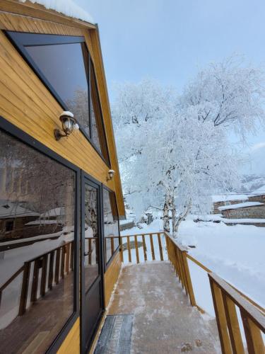 a winter view from the balcony of a house at Pine Chalet Kazbegi in Stepantsminda